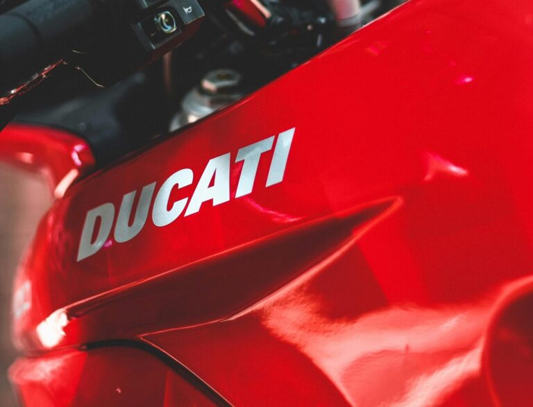 A detailed view of a red Ducati motorcycle dashboard and handlebars.