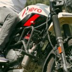 Man on a Hero motorcycle in a forest, perfect for outdoor adventure themes.