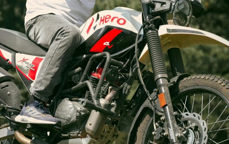 Man on a Hero motorcycle in a forest, perfect for outdoor adventure themes.