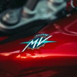Detailed view of a red MV Agusta motorcycle with focus on the emblem and metallic finish.