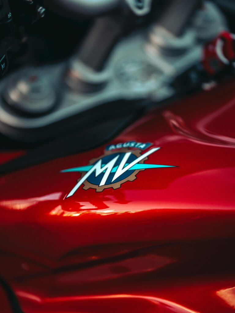 Detailed view of a red MV Agusta motorcycle with focus on the emblem and metallic finish.