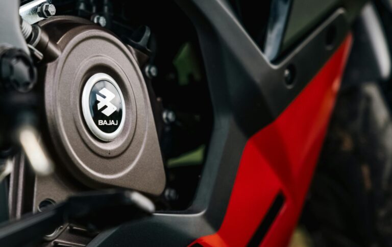 Detailed close-up view of a Bajaj motorcycle engine with striking red and black color scheme.