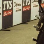 Dynamic motorbike stunt captured during a thrilling outdoor event with an excited crowd.