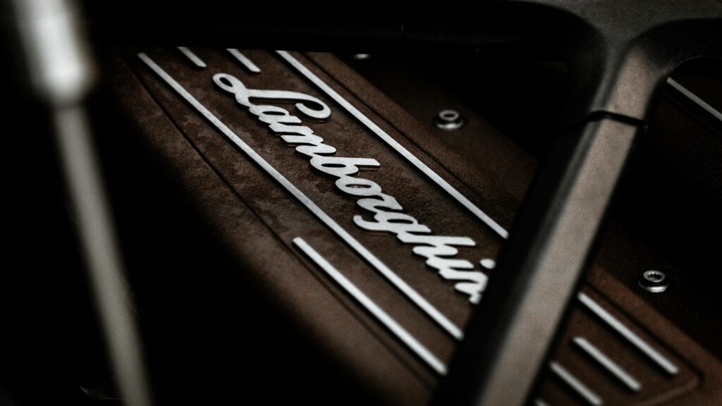 Detailed close-up of a Lamborghini engine emblem, showcasing luxury automotive design.